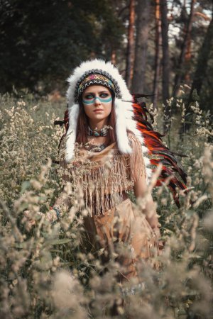 Téléchargez les photos : Belle femme indienne en cafard, robe à franges et maquillage sur son visage, se tient dans la forêt - en image libre de droit