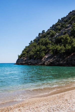Téléchargez les photos : Paysage touristique d'été en Grèce, île, plage de sable doré, baie, montagne avec rochers et forêt, mer avec eau turquoise et bleue, ciel bleu - en image libre de droit