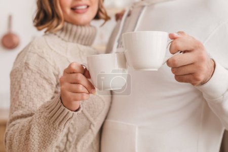 Téléchargez les photos : Heureux jeune couple joyeux famille boire le café du matin dans la cuisine, passer du temps ensemble à la maison. - en image libre de droit