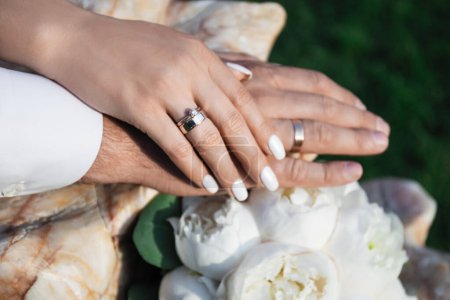Téléchargez les photos : Mains d'homme et de femme avec bouquet de mariage et anneaux. Mari et femme. - en image libre de droit