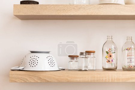 Téléchargez les photos : Étagère moderne avec différents plats et bouteilles sur fond de mur blanc - en image libre de droit