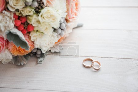 Téléchargez les photos : Alliances et un bouquet de mariage reposent sur un rebord de fenêtre en bois blanc - en image libre de droit