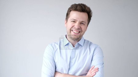The young European man confidently looks into the camera and smiles. Studio shot