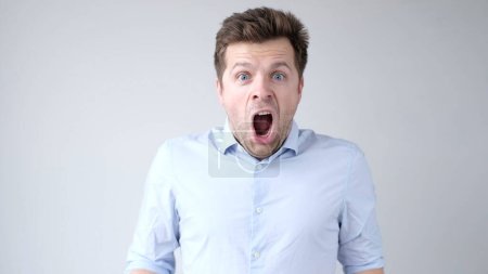 Photo for European young man is greatly surprised and opens his mouth in astonishment. Studio shot - Royalty Free Image