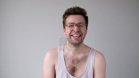 A funny European man with big glasses is laughing foolishly.