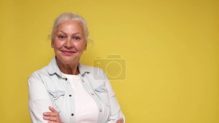 Une vieille Européenne à lunettes regarde la caméra avec confiance, souriante. Plan studio