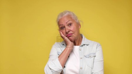 Une femme européenne âgée avec une expression triste éprouve de l'inconfort et de la tristesse. Plan studio