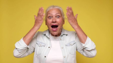 Foto de Una anciana europea se inspira, grita y levanta las manos en el aire. Captura de estudio - Imagen libre de derechos
