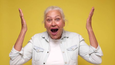 Una anciana europea se inspira, grita y levanta las manos en el aire. Captura de estudio