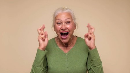 Eine ältere Europäerin drückt ihr die Daumen, um Glück zu haben. Studioaufnahme
