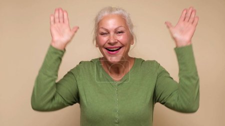 An elderly European woman is laughing. Studio shot