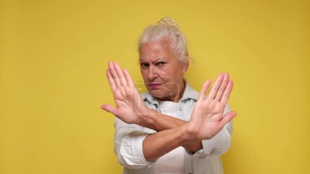 Elderly European woman showing a stop gesture with her hands