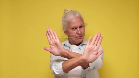 Anciana europea mostrando un gesto de stop con las manos