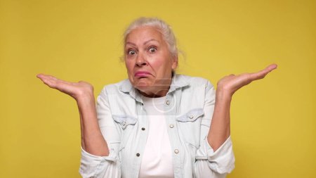 Femme européenne âgée haussant les épaules dans la confusion