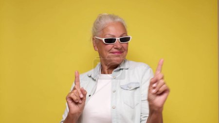 Photo for Elderly European woman in sunglasses is dancing. Studio shot - Royalty Free Image
