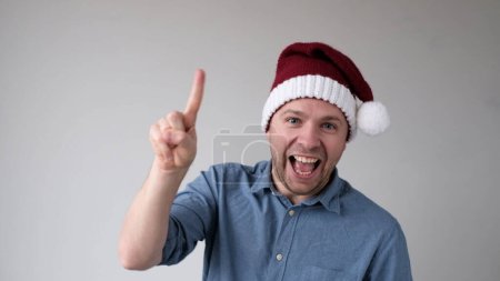 Funny Man in a New Year Hat Counts Fingers, wie zeigt Zahlen. Studioaufnahme