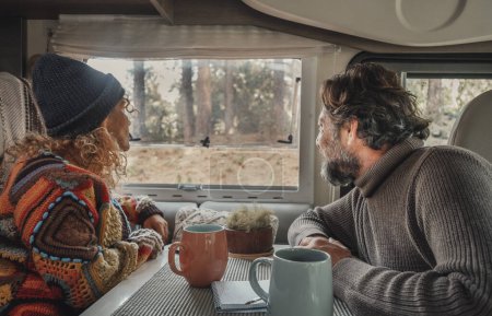 Photo for Young mature couple enjoy time inside camper van in van life lifestyle vacation. Travel people concept lifestyle. Admiring freedom nature park outdoors view outside the window. Rv vehicle renting - Royalty Free Image