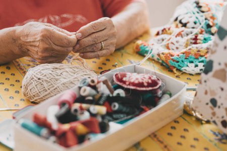 Photo for Close up of old mature woman hands working with crochet and sewing threads. Elderly indoor home leisure activity concept lifestyle. Unrecognizable senior female people in hobby active life. - Royalty Free Image