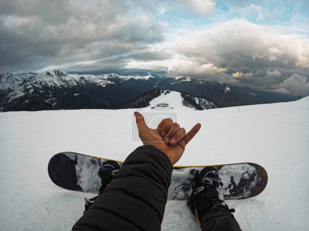Photo for People in winter mountains holiday vacation. Pov of legs and snowboard with landscape scenic view. Rider enjoying panorama and sky. One man resting in ski facilities. Active outdoor lifestyle - Royalty Free Image