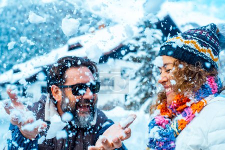 Photo for Man and woman have fun together with snow in mountains holiday vacation together. Happy couple in funny leisure activity outdoor together in winter cold season. Enjoyment and love lifestyle people - Royalty Free Image
