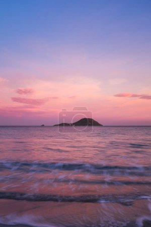 Téléchargez les photos : Pink color sunset on the ocean with island in background. Concept of travel and scenic place destination. Long exposure on ocean waves. Empty sky on horizon to write your text. Copy space. - en image libre de droit