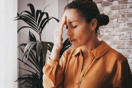 Photo for Tired stressed businesswoman feeling strong headache massaging temples exhausted from overwork, fatigued overwhelmed lady executive worker suffering from pain in head - Royalty Free Image