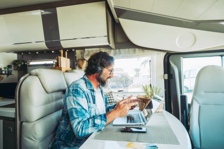 Photo for Modern online worker, smart working digital nomad lifestyle in camper van. Travel, people and technology. Alternative business job. Content creator influencer. Man using computer laptop and connection - Royalty Free Image