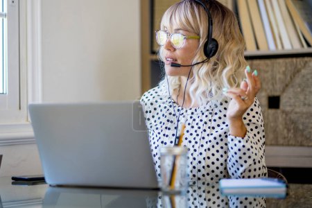 Téléchargez les photos : Customer service woman in smart working home office business online concept lifestyle occupation.  woman with headset speaking and explaining clients in remote communication modern technology. Freelance - en image libre de droit