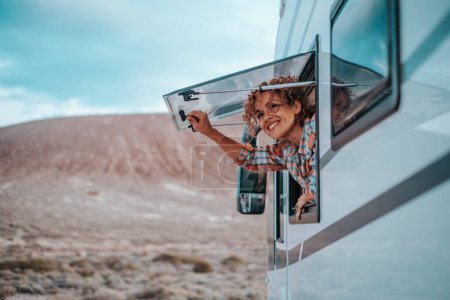 Photo for Happy woman traveler lifestyle opening camper van window and enjoying scenic parking outdoors landscape. Feeling of freedom. Alternative off grid tiny house people life. Vanlife travel independence. - Royalty Free Image