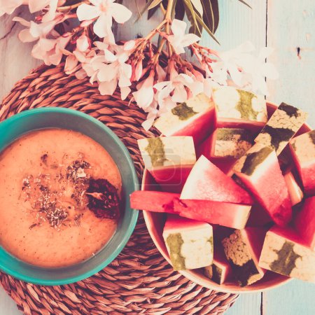 Photo for Top view composition of healthy food and lifestyle nutrition concept. Vegetarian and vegan soup with red watermelon fruit on a blue table ready for light lunch without calories. - Royalty Free Image