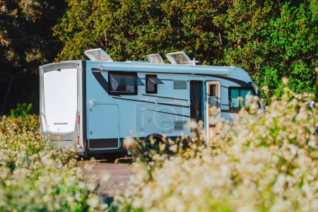 Téléchargez les photos : Camping-car camping-car moderne camping car garé dans la nature dans un parking gratuit et hors grille vanlife concept de vie. Voyage et vacances d'été location de véhicules vacances. Fond vert du parc naturel - en image libre de droit