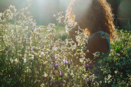 Photo for Woman feel emotion standing in the middle of blossom flowers meadow enjoying nature and life balance emotion. Positive mind. Healthy natural lifestyle. People enjoying green environment and love alone - Royalty Free Image