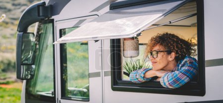 Photo for Daydreamer serene and happy female tourist people enjoying trip destination admiring nature outdoor at the camper van window. Living off grid alternative tiny house on wheels. Renting vehicle vacation - Royalty Free Image