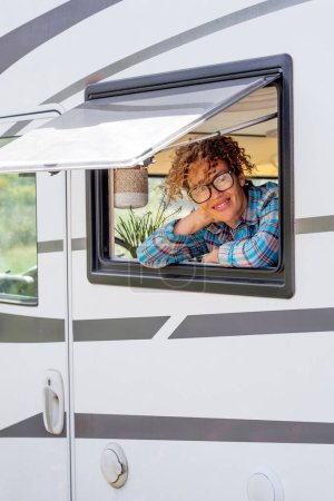 Photo for Happy tourist enjoy travel vacation destination inside a modern camper van looking on camera outside the window. Alternative free nomadic people lifestyle in camper van. Adventure holiday van life - Royalty Free Image