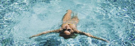 Photo for Active female swimming in blue pool water and enjoy summer holiday vacation. People in outdoor leisure activity. Lady in relaxation day swim and enjoy relax. Banner header. Healthy lifestyle - Royalty Free Image