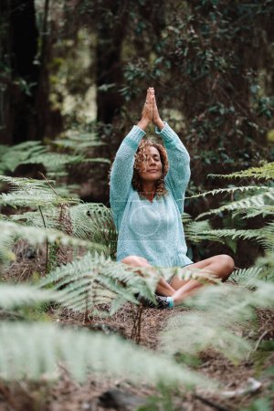 Foto de Mujer sana natural meditar práctica final ejercicio de yoga en el bosque bosques verdes disfrutando de la actividad de ocio al aire libre en la naturaleza. Bienestar y ejercicio consciente, gente afuera. La gente medita - Imagen libre de derechos