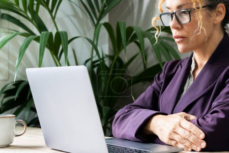 Photo for Close up portrait of confident serious businesswoman entrepreneur looking computer. Online business job difficulties. Businesswoman thinking in front of a laptop. Problems and solutions at online job - Royalty Free Image