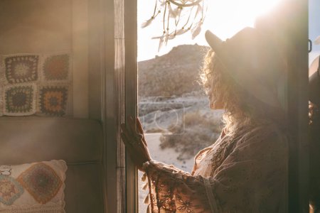 Photo for Dreamer travel woman admiring sunset light and landscape standing on the door of her tiny motor home house. Wanderlust and female traveling solo. People enjoying freedom and van life lifestyle - Royalty Free Image
