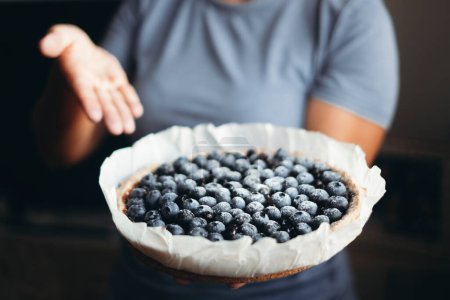 Photo for Close up of healthy and natural handmade blueberries cake. Homemade bakery concept food. Unrecognizable woman in background. Natural healthy lifestyle nutrition, dieting cakes. Berries fruit. - Royalty Free Image