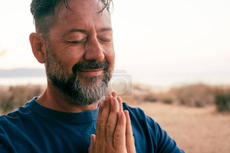 Foto de Hombre adulto orando y meditar al aire libre en el gesto de relajación - Imagen libre de derechos
