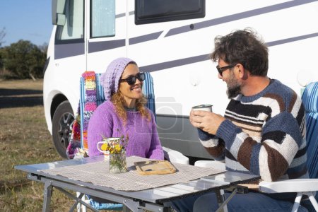 Photo for Travel and camping people lifestyle outdoor leisure. Couple with adult man and woman enjoying time together outside a camper van. Alternative tourism and home lifestyle people. Getting away. Freedom - Royalty Free Image