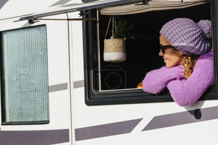 Photo for Happy solo traveler woman enjoy view and have relax leisure activity alone looking outside the window of her camper van rv vehicle. Travel people lifestyle. Modern vanlife adult female people - Royalty Free Image