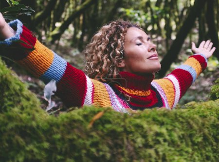 Photo for Profile of a relaxed woman breathing fresh air in a green forest. Environment and healthy lifestyle female people in outdoor leisure activity opening arms and hugging nature with love. Forest travel - Royalty Free Image
