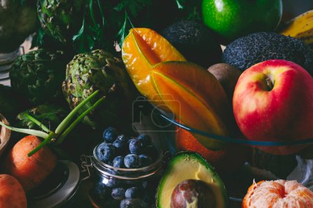 Photo for Mix of colorful fruits and vegetables in dark blak mood colors on the table. Concept of healthy lifestyle and diet nutrition plan.  Salad ingredients and natural bio organic store products - Royalty Free Image