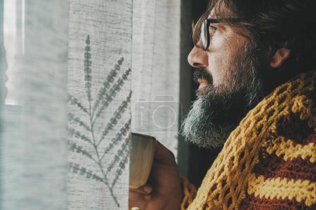Photo for Man suffering cold temperature condition inside home for gas energy saving and price bills. Side view of male people drinking coffee or tea. Influenza flu cold symptoms and bad health condition - Royalty Free Image
