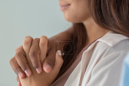 Foto de Close up of interracial couple holding hands with love and romantic relationship. Caucasian woman hold black man hand and smile. Dating and new family concept. People having care - Imagen libre de derechos