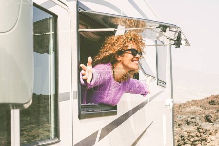 Photo for Overjoyed and excited adult pretty woman admire outside the camp van - Royalty Free Image