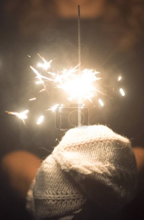 Photo for Vertical copy space image of hands holding a fire sparkler to celebrate new year eve or christmas time. People close up for celebration and holiday fun. Freedom and hope. Daydreamer female - Royalty Free Image