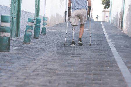 anciano con una prótesis de titanio pierna izquierda camina suavemente en un parque de la ciudad