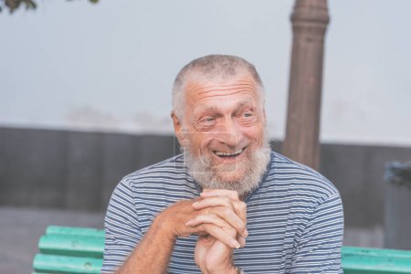 75 años de edad, hombre mayor se ríe mientras se divierte al aire libre.